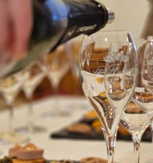 a person pouring wine into wine glasses on a table