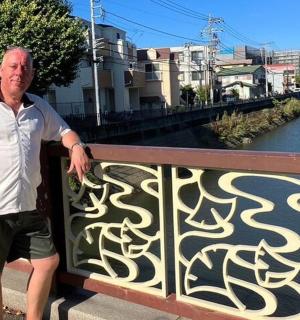 一名男子站在河边的篱笆上