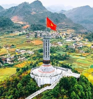 a flag flying on top of a tower with a city