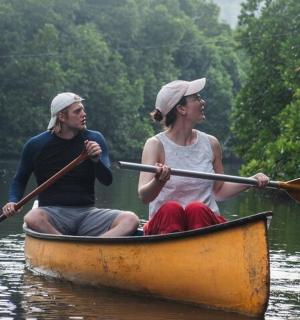 a man and a woman in a canoe on the water