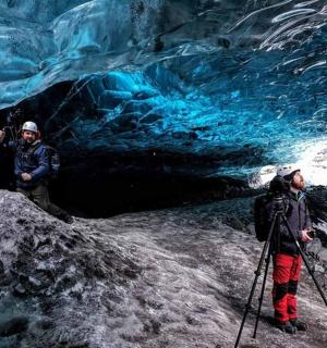 两个人站在冰洞前