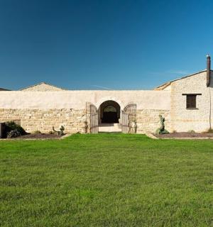 a large stone building with a green field in front of it