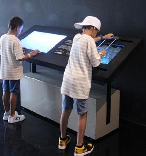 two young boys standing in front of a table
