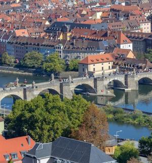 eine Brücke über einen Fluss in einer Stadt mit roten Dächern