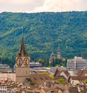 město s hodinovou věží před horou