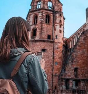 a woman holding a cell phone in front of a building