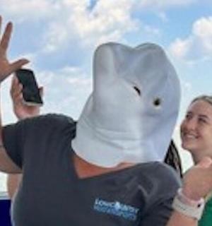 a woman taking a picture of a person wearing an elephant head