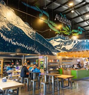 restaurace se stoly a velkou nástěnnou malbou hory