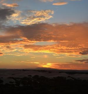 a sunset in the desert with clouds in the sky