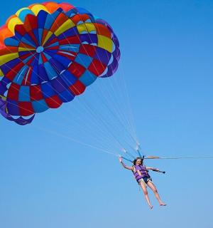 a person riding a parachute in the sky