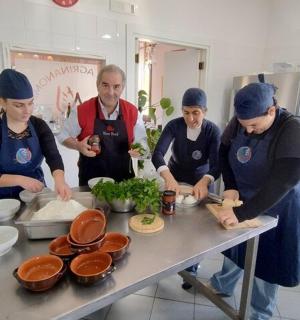skupina lidí v kuchyni připravujících jídlo