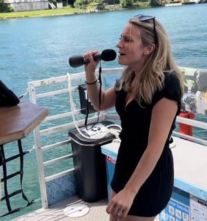 một người phụ nữ hát vào micro trên thuyền