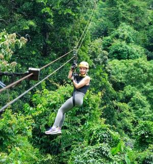 a woman is zip lining through the trees