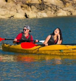 一男一女在水上的黄色皮划艇上