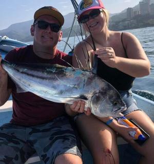 एक आदमी और औरत नाव पर मछली पकड़े बैठे हैं