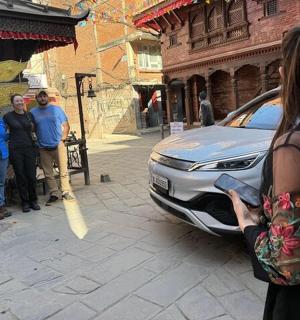 一名女子在街上拍摄一辆汽车