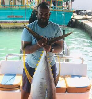 一名男子在船上抱着一条大鱼