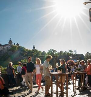 eine Menschenmenge, die vor einem Schloss um Tische herumsteht