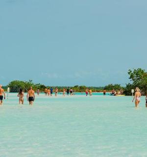 eine Gruppe von Menschen steht im Wasser an einem Strand