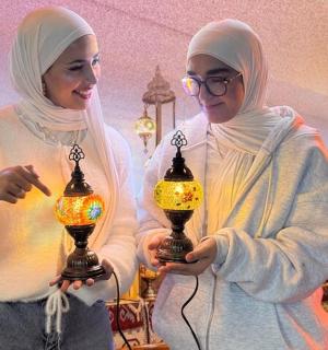 Dvě ženy drží lampu v místnosti