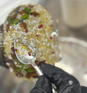 osoba v černých rukavicích držící lžíci s jídlem