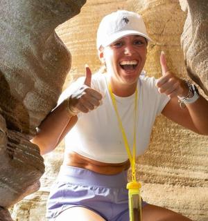 a man giving the thumbs up while rock climbing