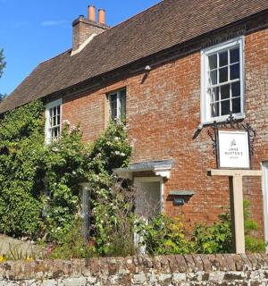 an old brick house with a sign in front of it