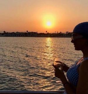 一位女士站在船上欣赏日落