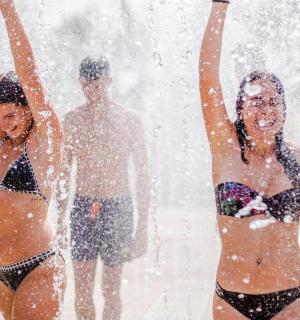 两名身着泳衣的女子在喷泉里玩耍