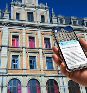 a person holding a cell phone in front of a building