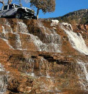 一辆吉普车停在瀑布顶上