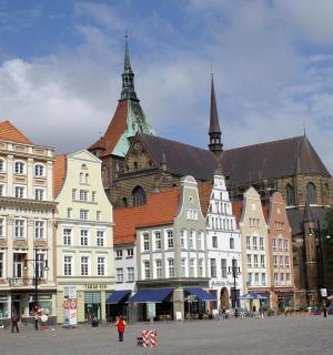 a group of buildings with people walking in a square