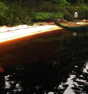 一名男子站在水中的船上