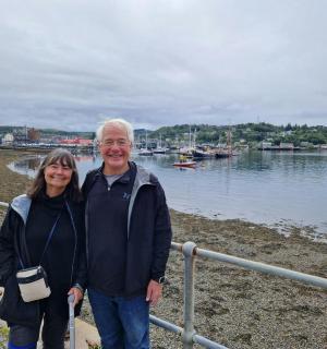 a man and a woman standing next to the water