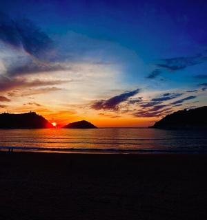 พระอาทิตย์ตกบนชายหาดพร้อมกับมหาสมุทรและท้องฟ้า