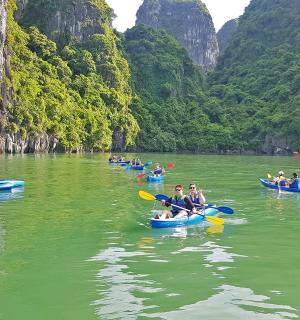 a group of people in kayaks on a river with mountains