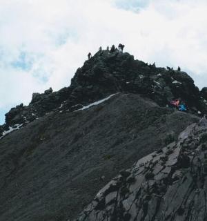 egy csoport ember áll egy hegy tetején