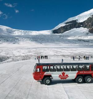 一辆红白相间的巴士停在白雪皑皑的山上