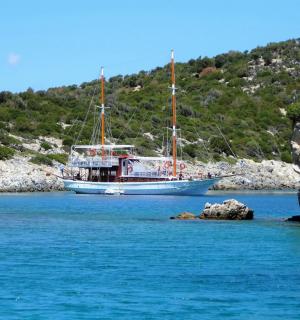 a boat sitting in the water next to a mountain