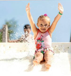 ein kleines Mädchen auf einer Wasserrutsche