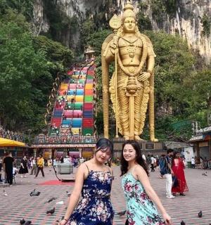 两名女子站在城市中的一座雕像前