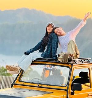 muž a žena sedící na střeše auta