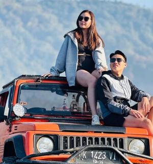 dva lidé sedící na střeše džípu