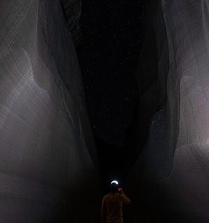 a man taking a picture of a dark tunnel