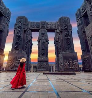 a woman in a red dress standing in front of a building