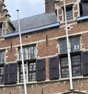 a red brick building with black shuttered windows