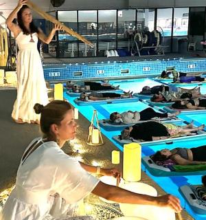 skupina lidí cvičících jógu v bazénu