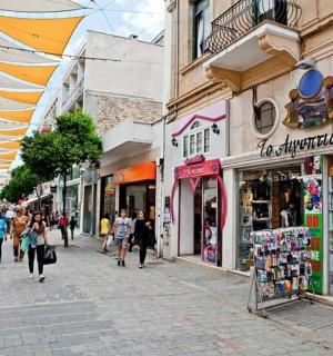 a group of people walking down a street with shops