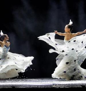 two women in white dresses dancing on the stage