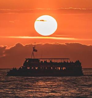 loď v oceánu se západem slunce v pozadí